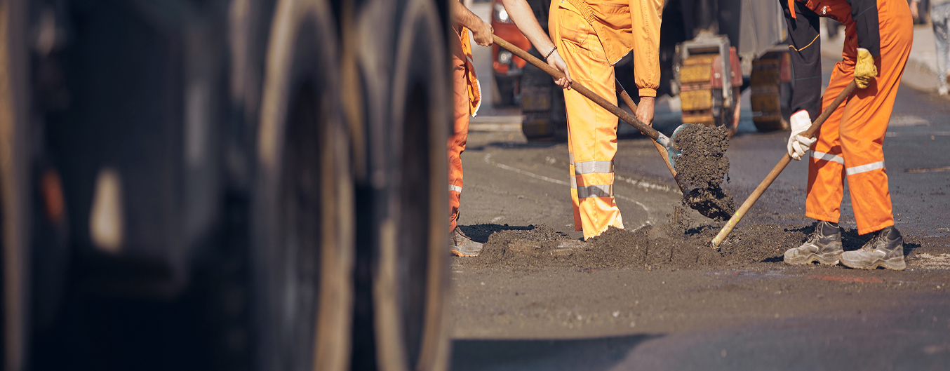 Terrain pétanque maison terminé dans un grand jardin, rectangle de sable compacté bordé de traverses en bois, arbres et campagne en arrière-plan.